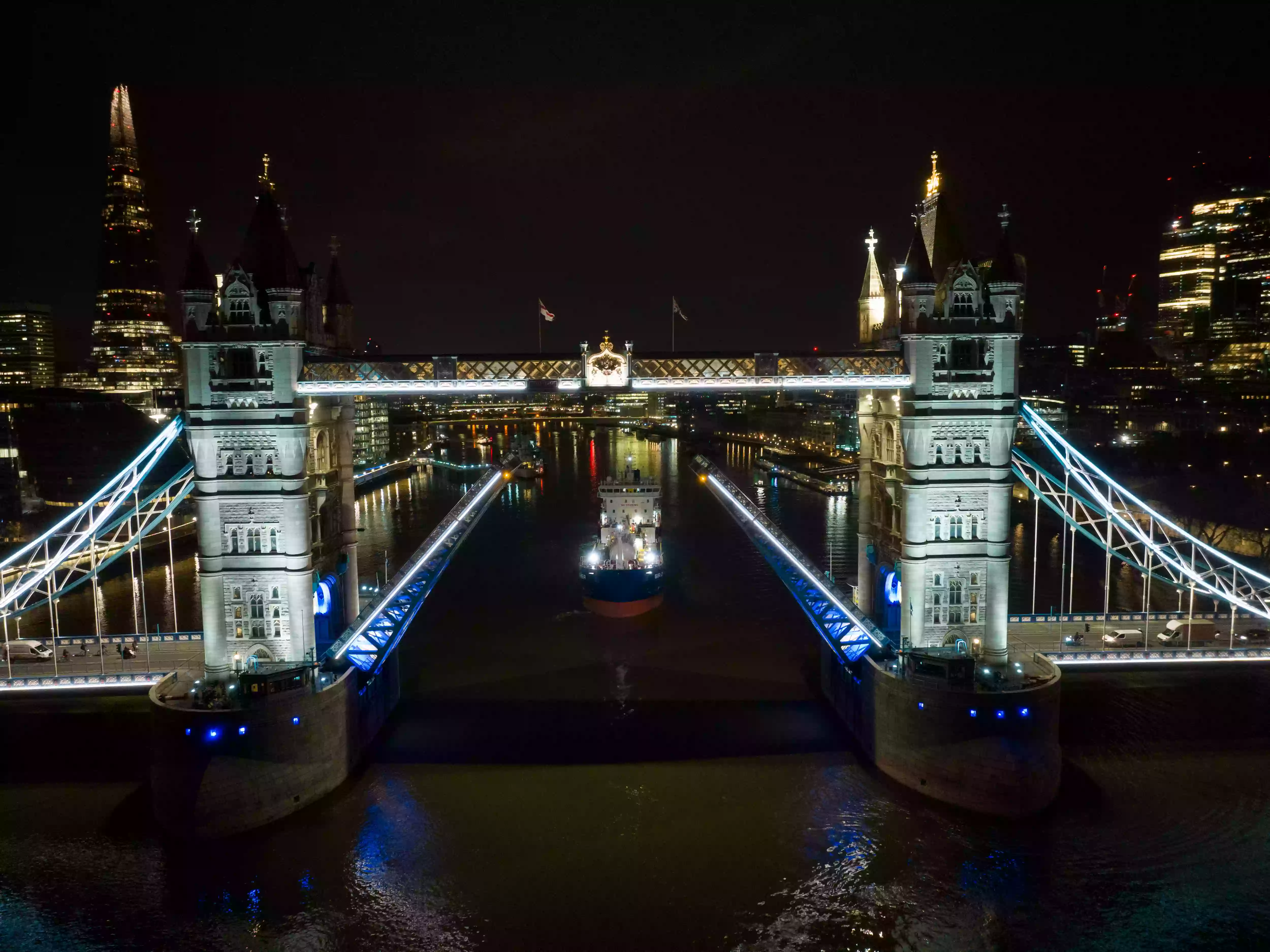 Tower Bridge illuminated at night during the pre-dawn arrival of the Sir John Fisher on the River Thames
