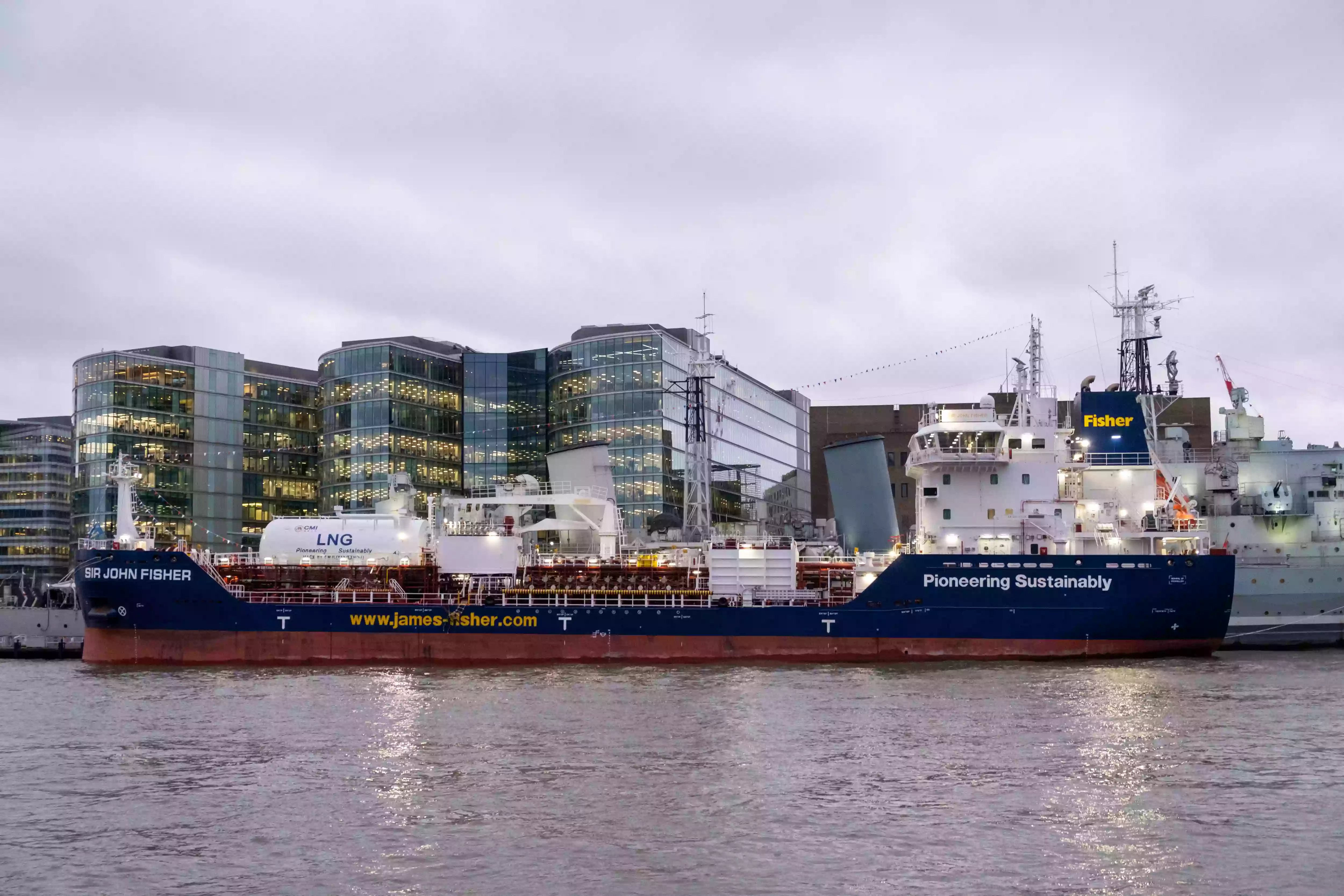 Sir John Fisher moored alongside HMS Belfast in the Pool of London ahead of her official naming ceremony