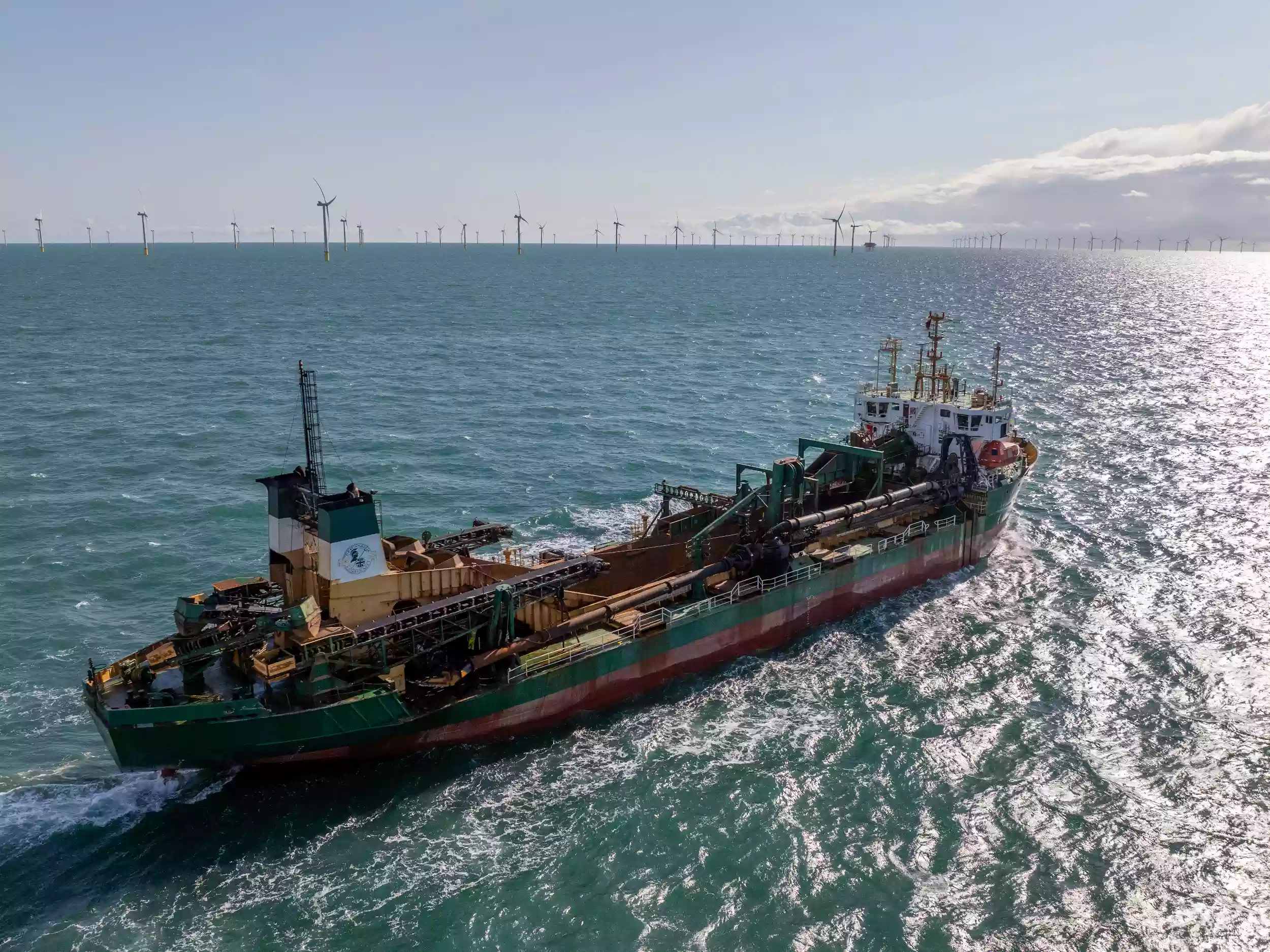 Aerial drone view of the Britannia Beaver sailing past an offshore wind farm in the English Channel during a Brett Group production shoot.