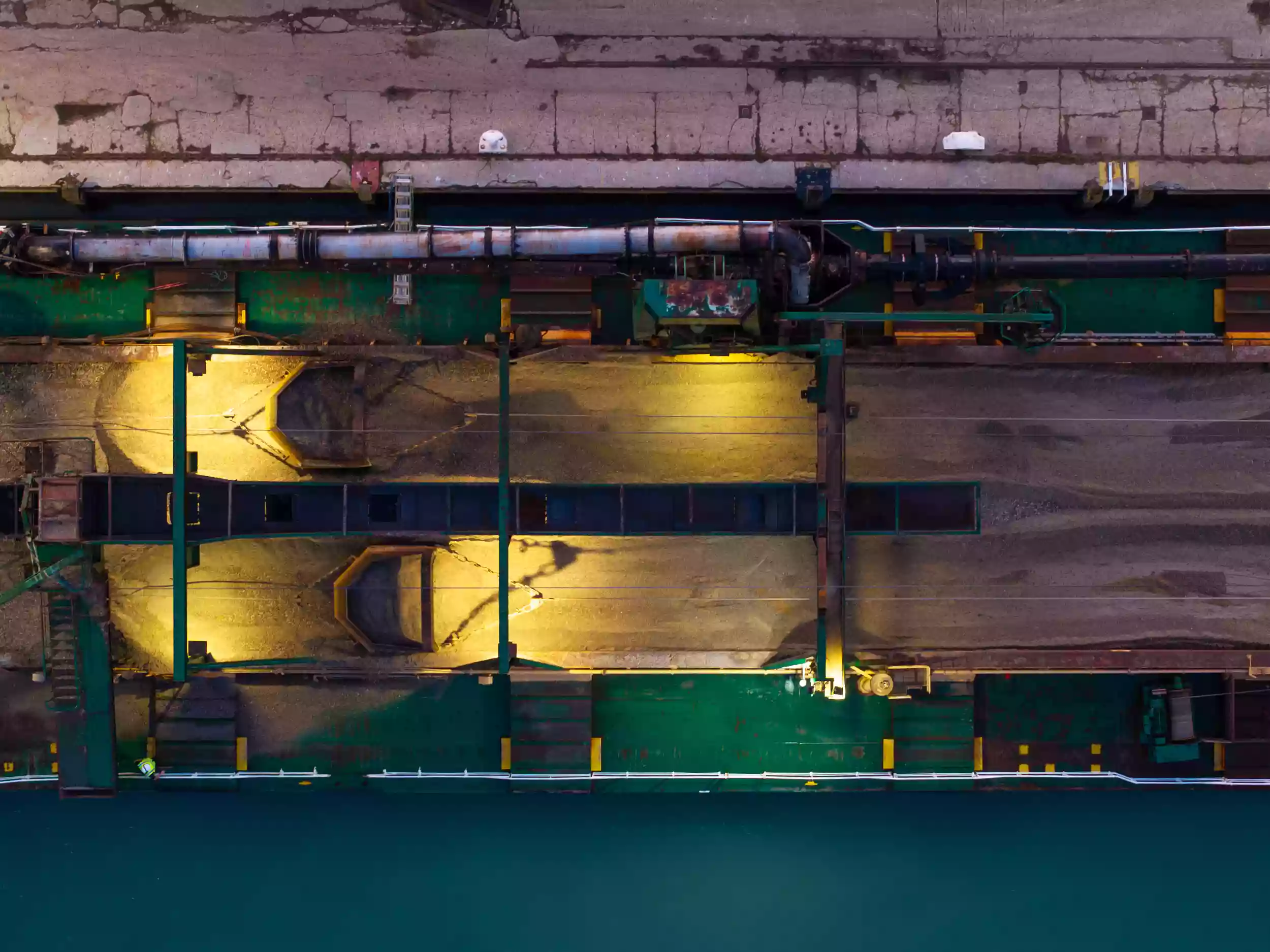 Twilight aerial drone view of Newhaven Port with the Britannia Beaver moored alongside, surrounded by dockside infrastructure.