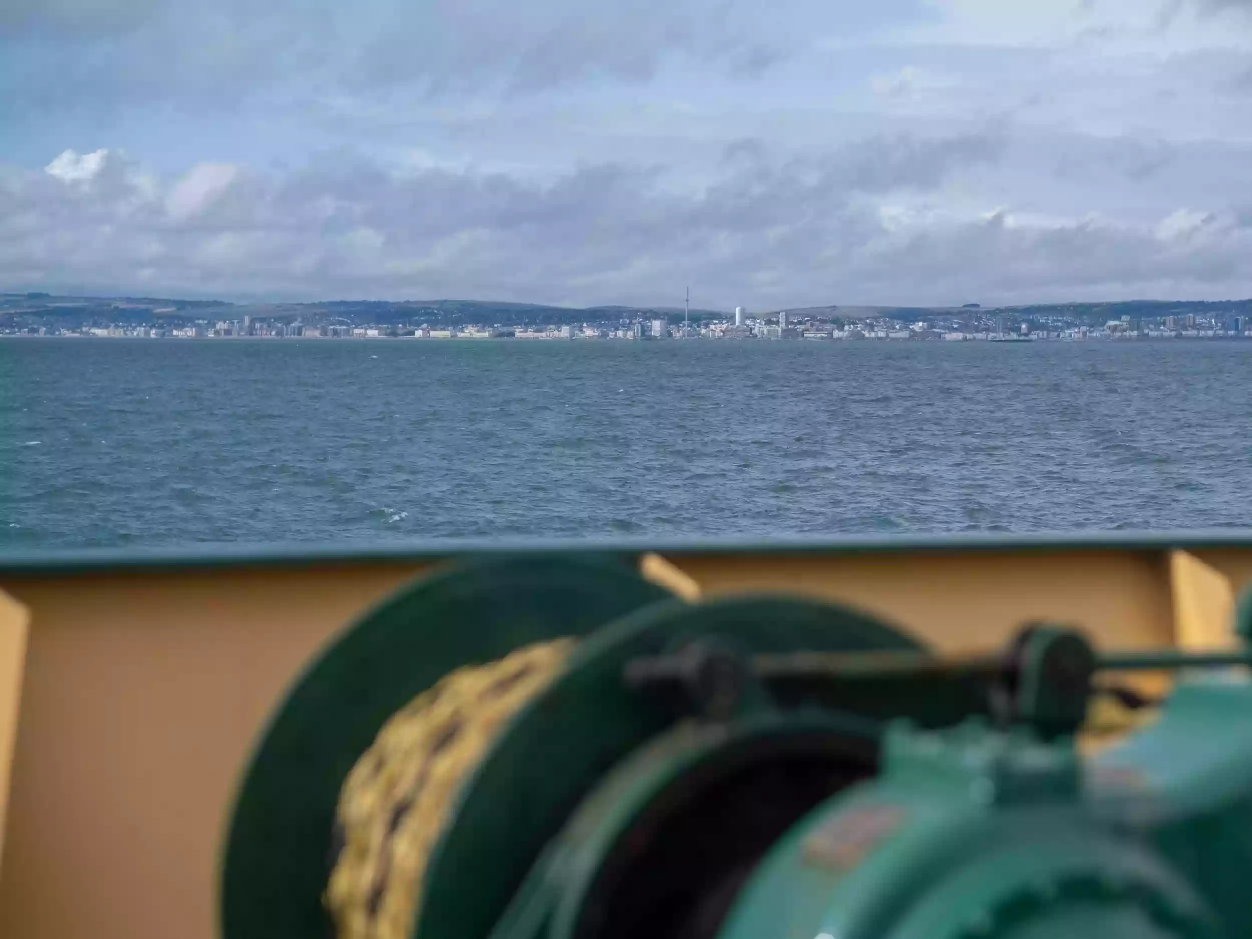 On-board view of dredging equipment in operation, with water and sediment moving across the deck of the Britannia Beaver.