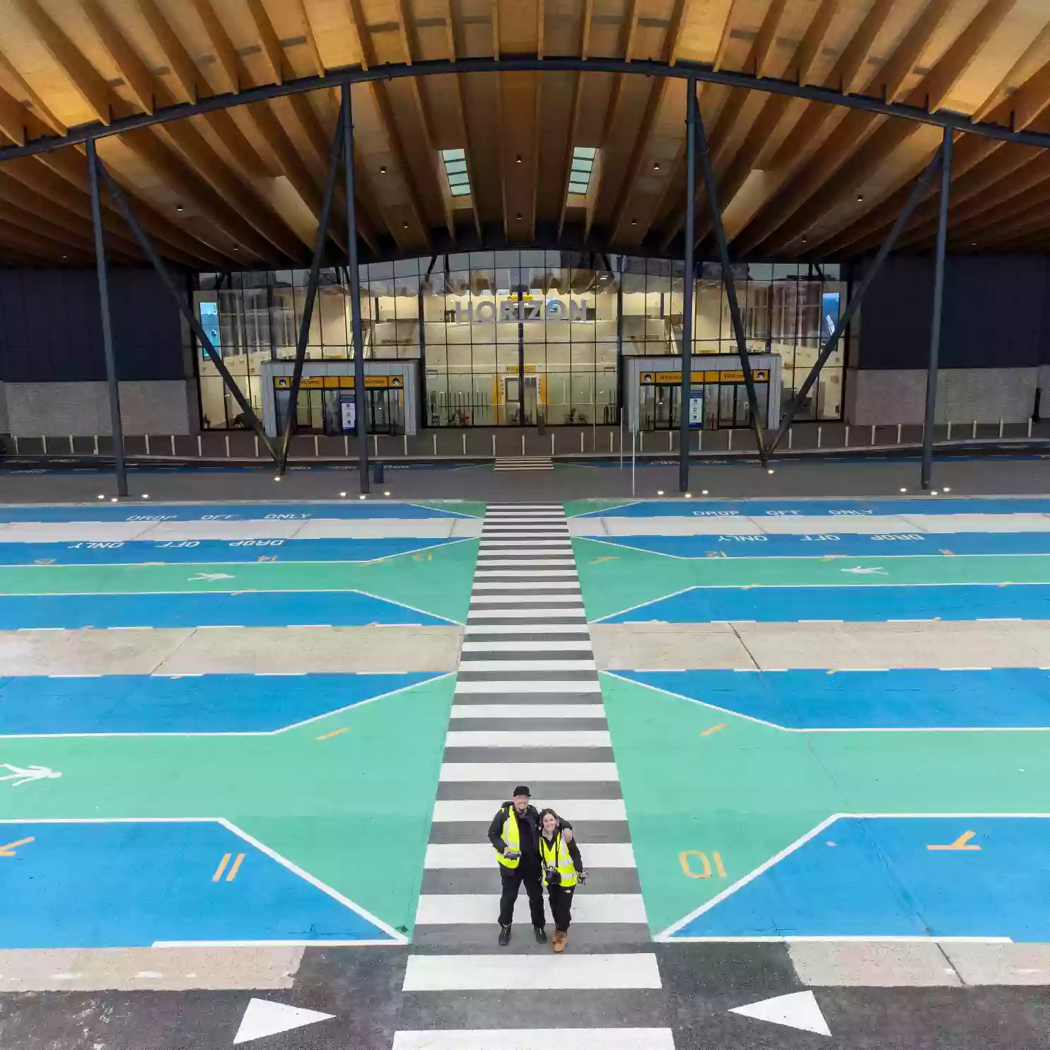 Aerial view of a cruise ship's pool deck at the Port of Southampton, with crew member visible on deck.