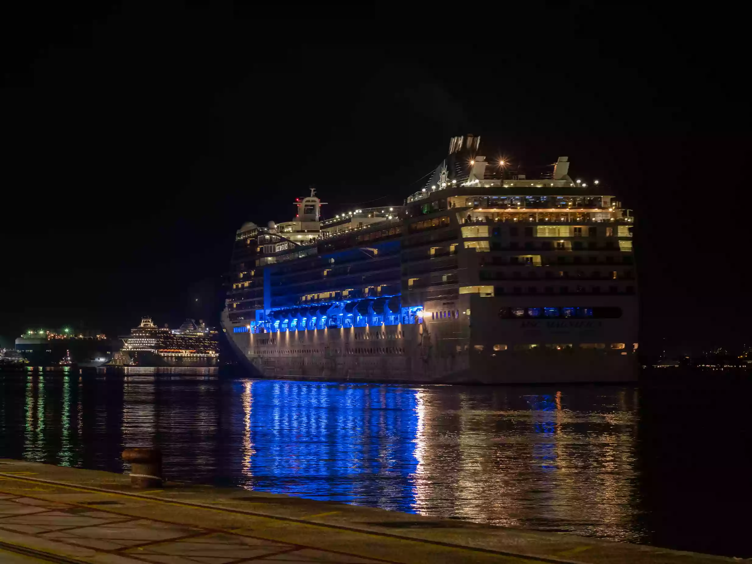 Cruise ship lit up at night alongside a terminal at the Port of Southampton.