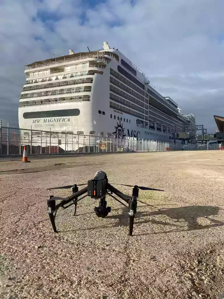 Drone ready for take off in front of a large cruise ship at the Port of Southampton cruise terminal.