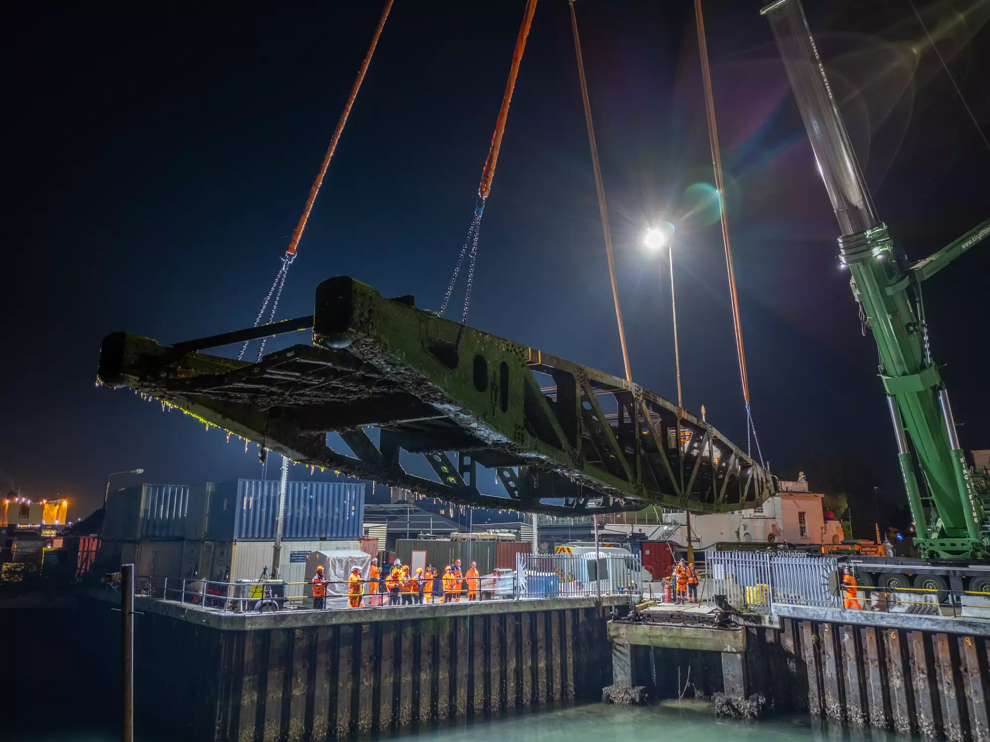 Mulberry Harbour Whale roadway section suspended mid-lift at night, filmed by drone for Associated British Ports